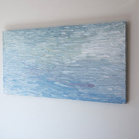 A abstract painting with blue textured brushstrokes is seen at an angle on a gallery wall.