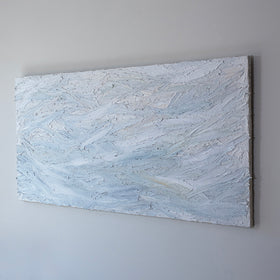A white and light blue abstract painting with thick, impasto brushstrokes is seen at an angle on a gallery wall.