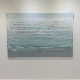 A video of a white, teal and grey heavily textured abstract painting like sculpture by Teodora Guererra hangs on a white wall in natural light.